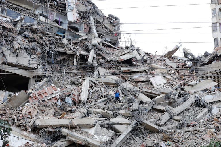 A man walks among the rubble of a building that collapsed in earthquakes the previous day in La Guaira, Venezuela, Thursday, June 25, 2026. (AP Photo/Pedro Mattey)