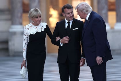 El presidente de Francia, Emmanuel Macron (centro), y su esposa, Brigitte Macron (izq.), reciben al presidente de Estados Unidos, Donald Trump (der.), en el Palacio de Versalles antes de una cena para conmemorar el 250.º aniversario de la independencia de Estados Unidos, el 17 de junio de 2026, en Versalles, al sudoeste de París.
