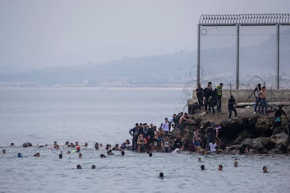 Migrantes cruzan nadando al enclave español de Ceuta, cerca de la frontera de Marruecos y España