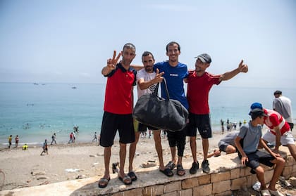 Jóvenes migrantes de hacen una foto en el cruce a Ceuta; la viralización de los cruces exitosos fue un aliciente