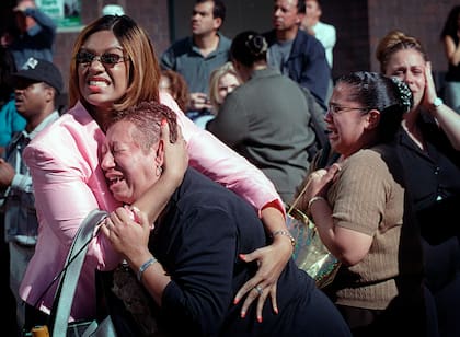 Dos mujeres se abrazan mientras ven arder el World Trade Center en Nueva York